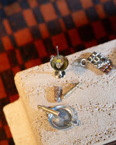 Styled image featuring the Joint Charm, Lit Joint Charm, Dirty Martini Charm and Chocolate Bar Charm.