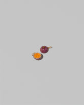 View from the back of the Halved Passion Fruit Charms on light color background.