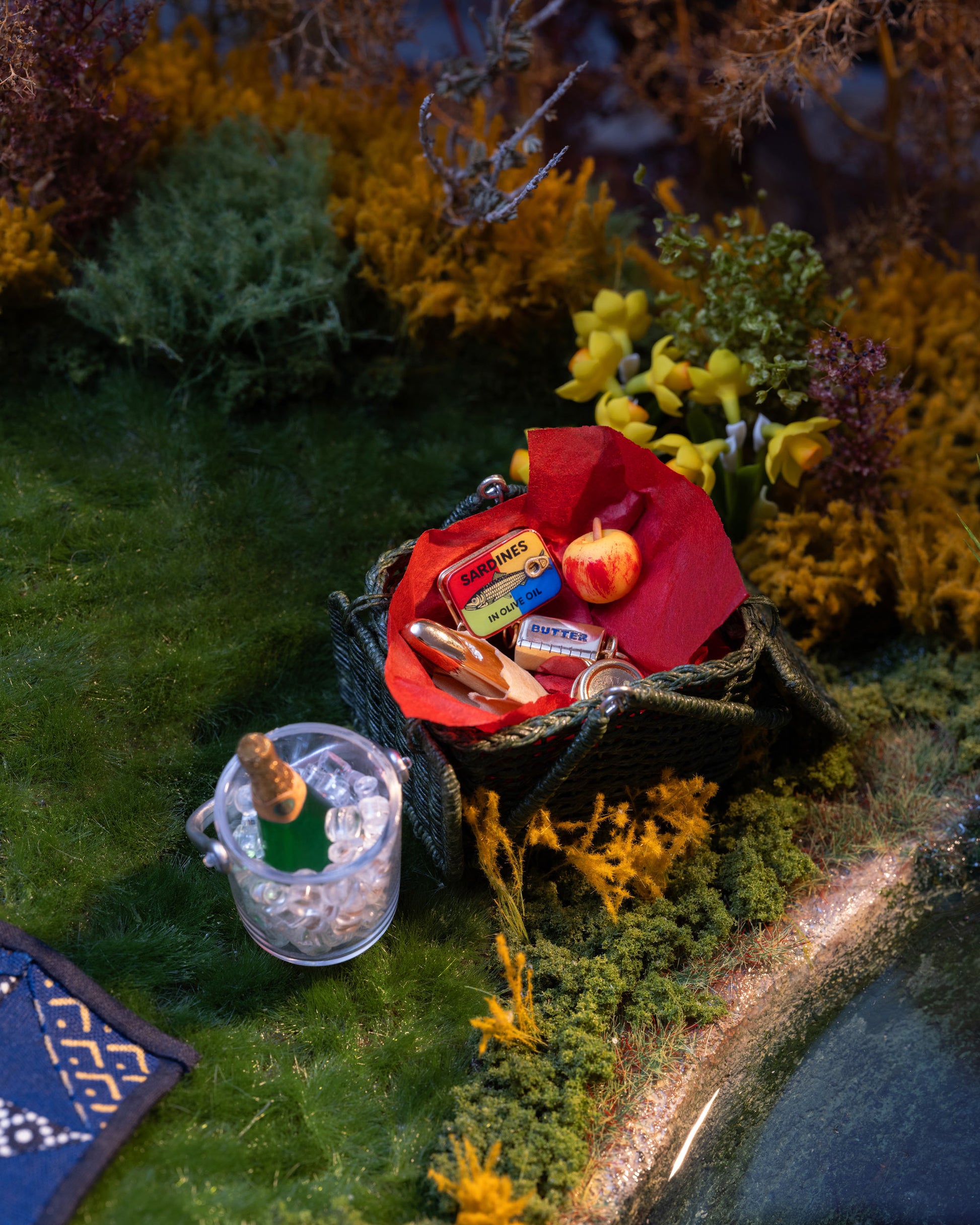 Styled image of the Sardine Can Charm, with the Luna Ring Charm, Sardine Can Charm, California Poppy Charm, Daffodil Charm, Sardine Fish Charm, Demi Baguette Charm and Caviar Charm.