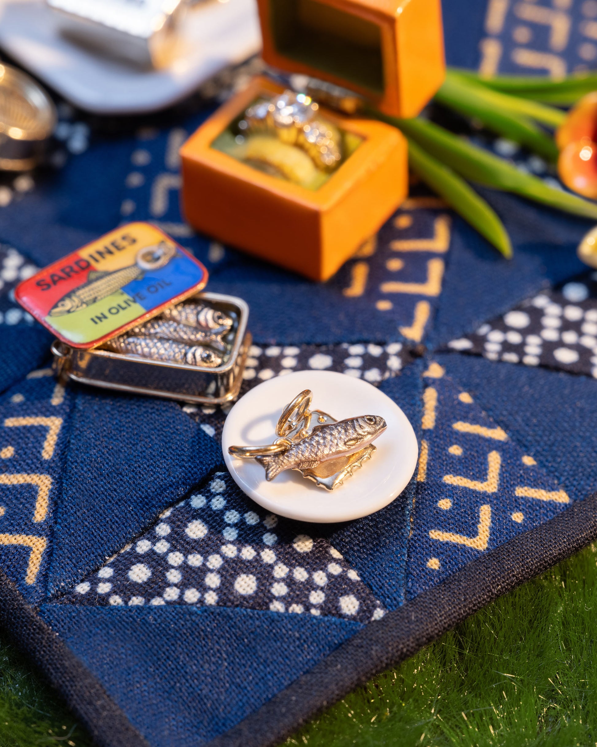 Styled image of the Sardine Fish Charm, with Saltine Charm, Sardine Can Charm and Luna Ring Charm.