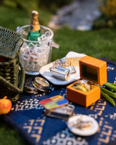 Styled image of the Salted Butter Charm, with Saltine Charms, Caviar Charm, Sardine Can Charm and Luna Ring Charm.