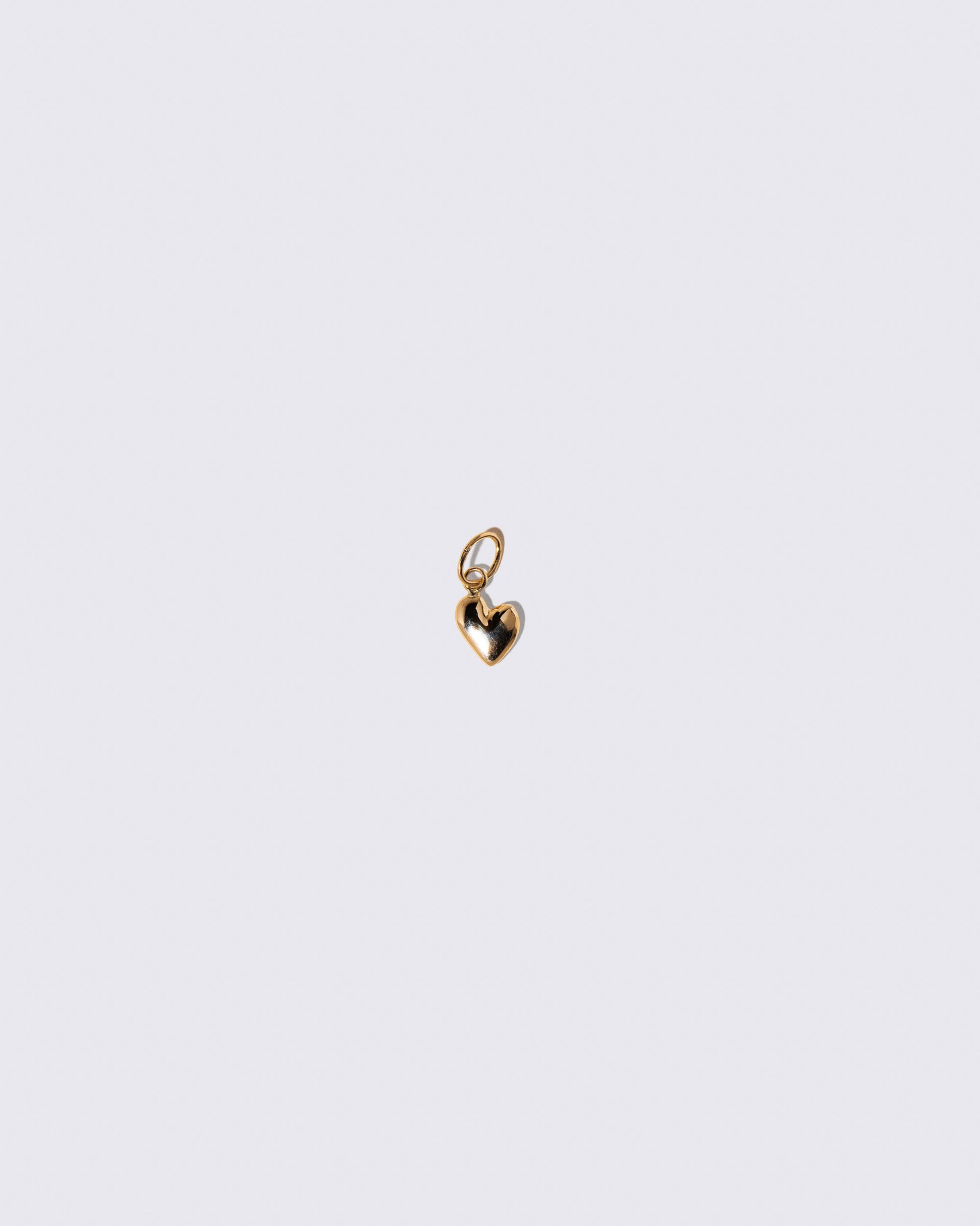 Gold Thousand & One Night Heart Charm on light color background.