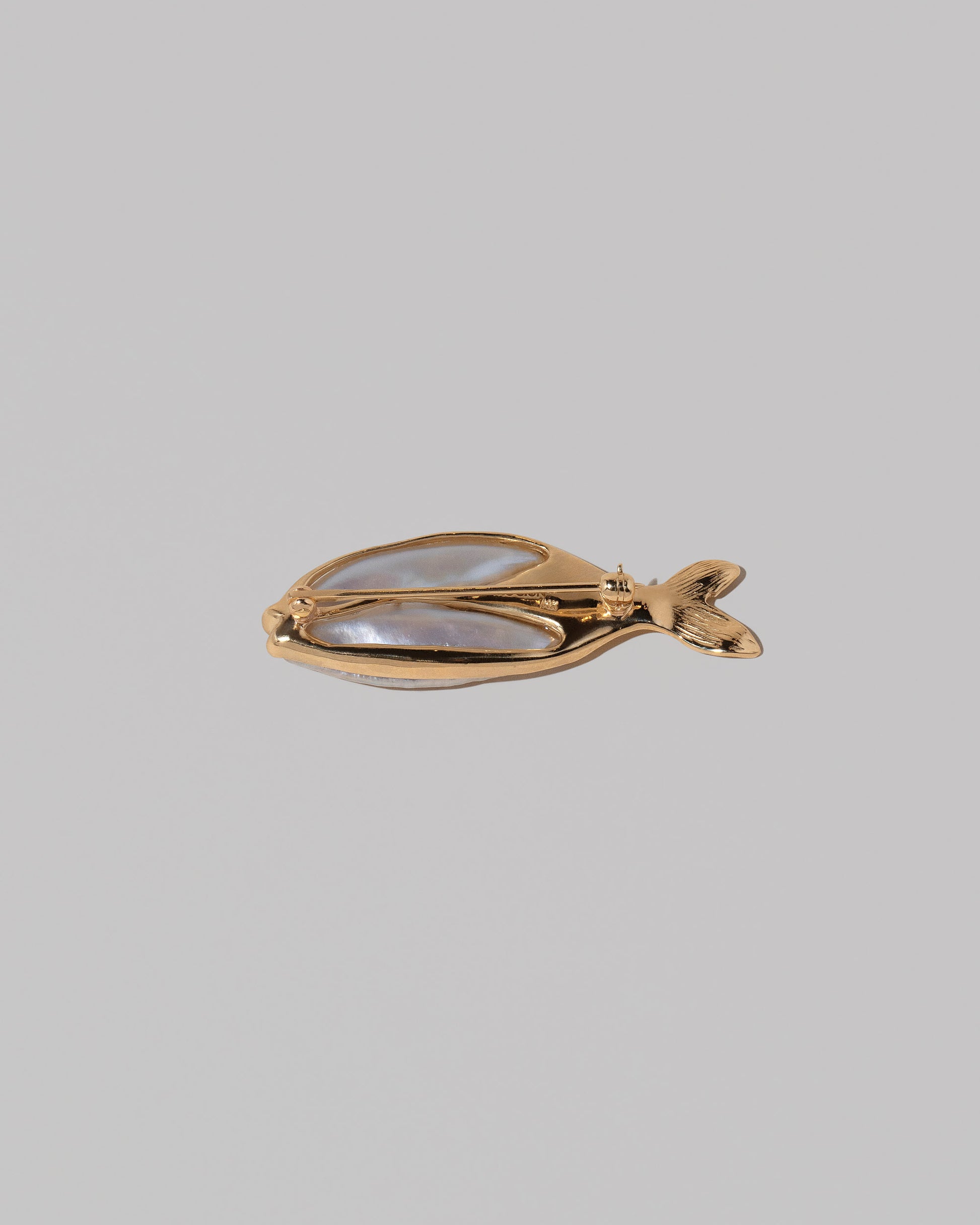View from the back of the Frank Fish Brooch on light color background.