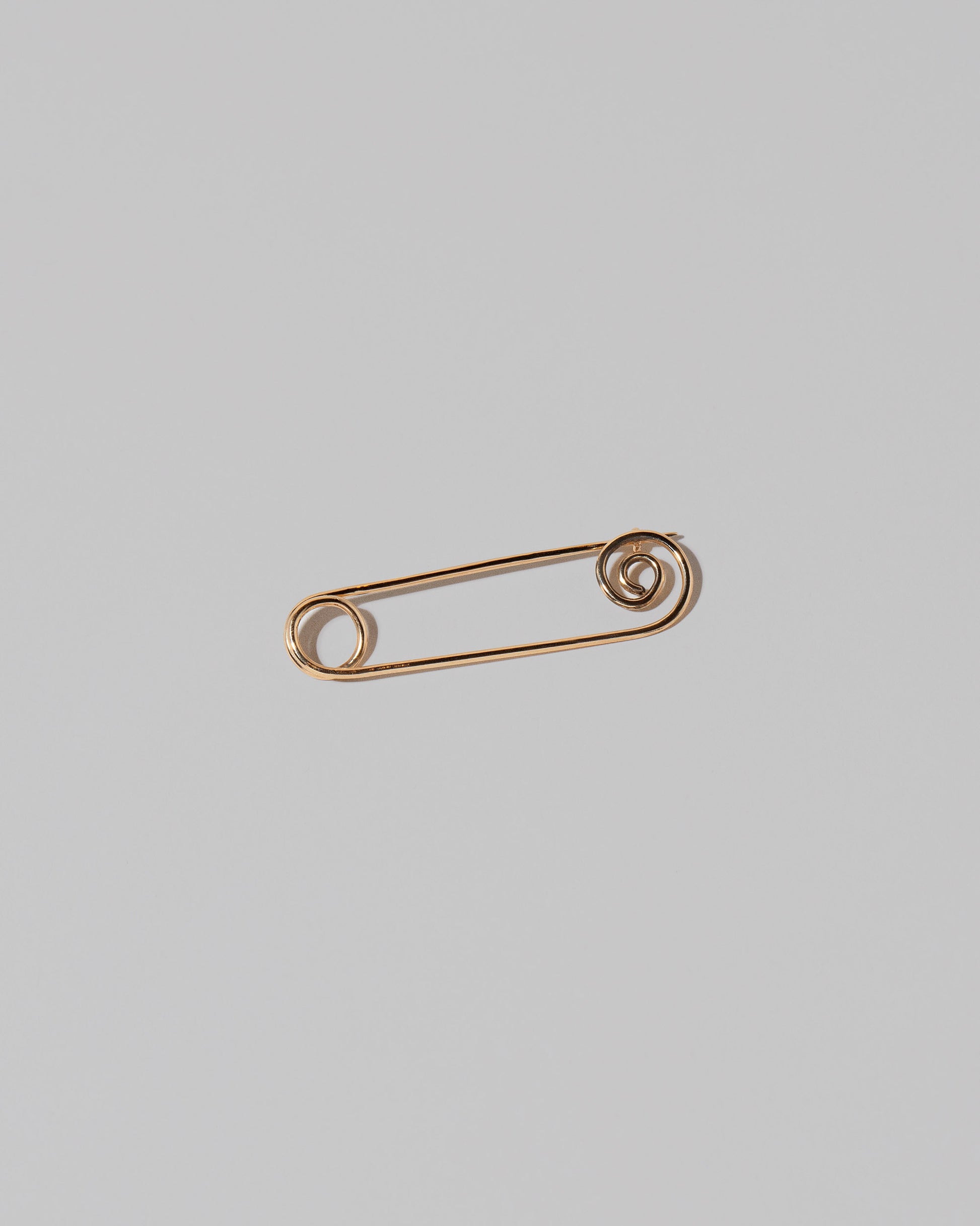Spiral Pin Brooch on light color background.