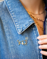 Spiral Pin Brooch with Loop & Sphere Talisman Charm, Eye Talisman Charm, Gold Small Thousand & One Night Heart Charm, North Star Talisman Charm and Sardine Fish Charm on model. Charms sold separately.