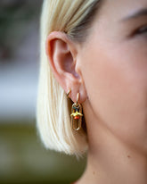 Daffodil Charm paired with Solid Link Huggie Hoop Earrings and styled with Huggie Gold Solid Snack Hoop Earrings on model.