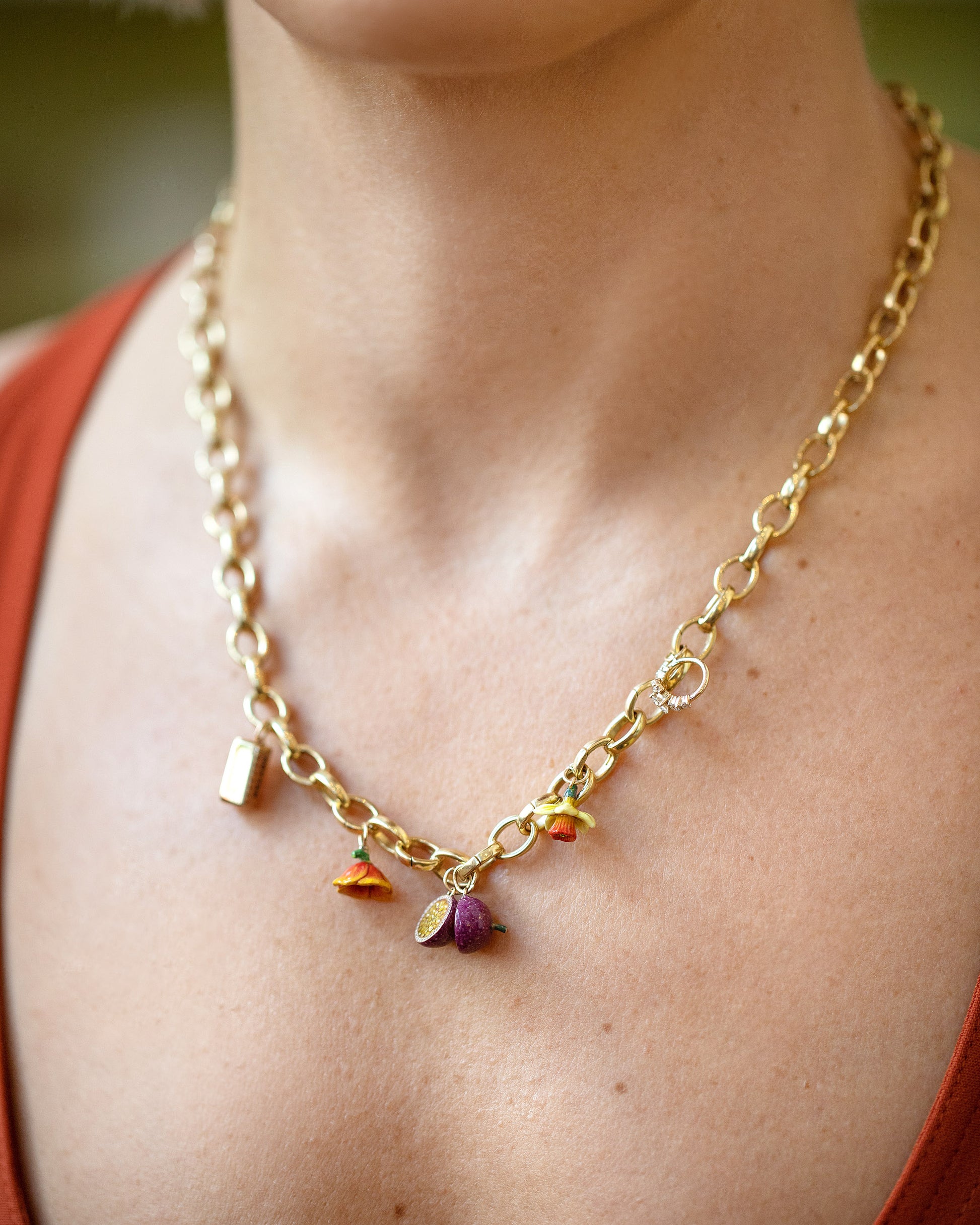 Stick of Salted Butter Charm, Passion Fruit Charms, California Poppy Charm, Daffodil Charm and Luna Ring Charm paired with Gold Endless Clasp Bracelets worn as a a necklace on model