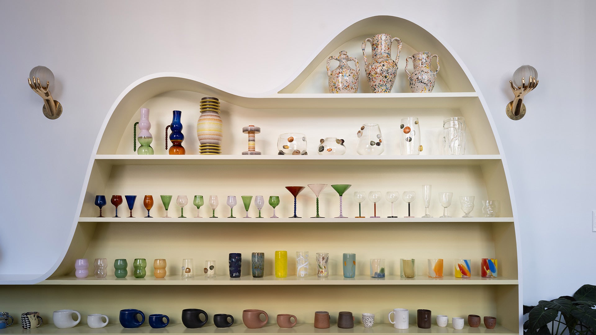 Details view of colorful glassware and handmade ceramics staged in a custom, free-form display at the Mociun Williamsburg Brooklyn Showroom.