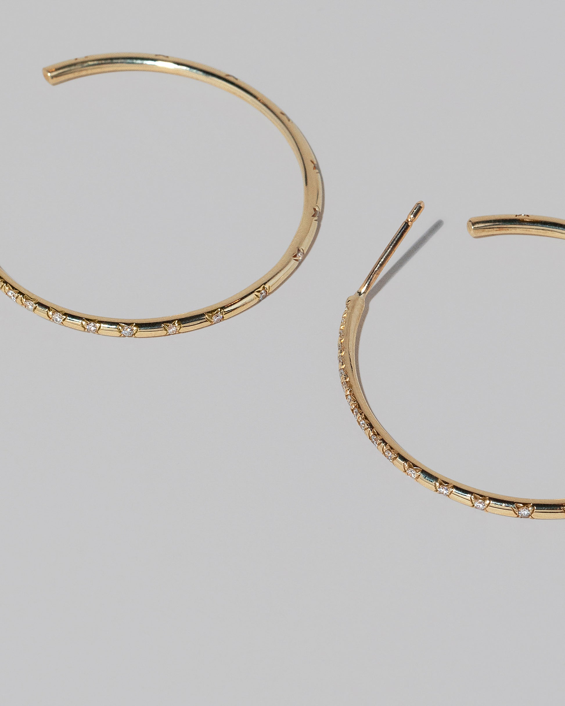 Closeup details of the Pave Diamond Hoop Earrings on light color background.