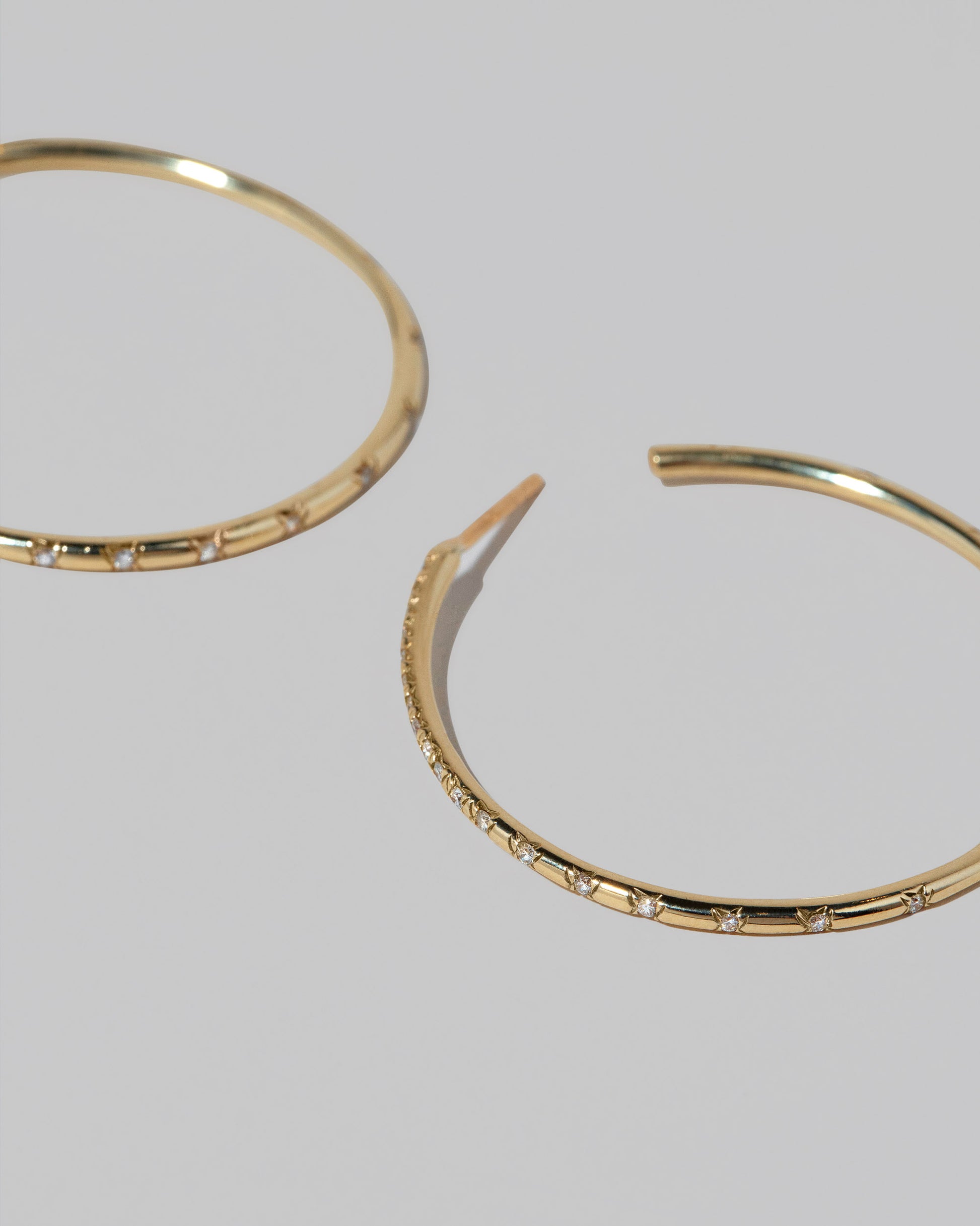 Closeup details of the Pave Diamond Hoop Earrings on light color background.