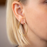 product_details::Pave Diamond Hoop Earrings and Huggie Gold Solid Snack Hoop Earrings on model.