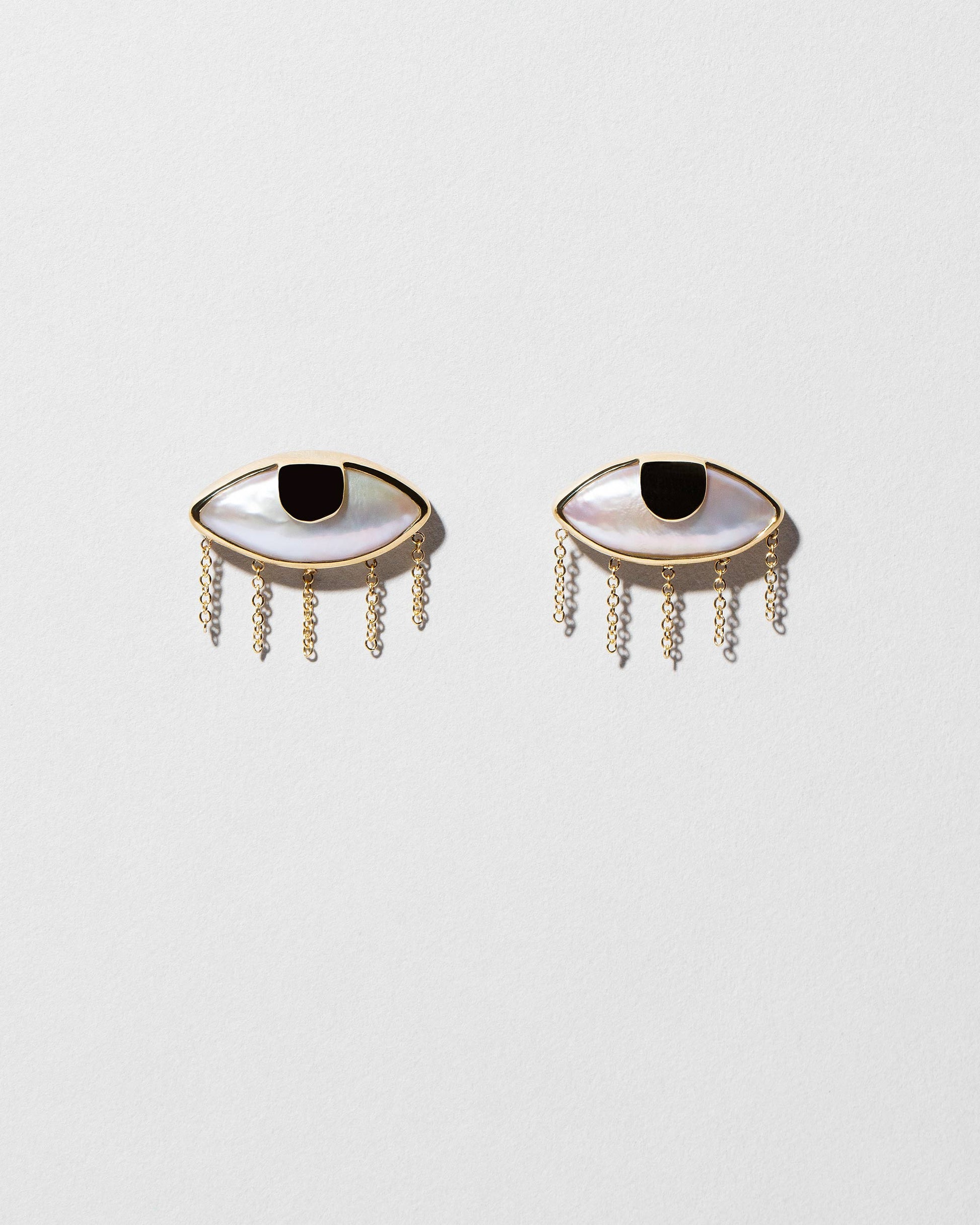 Pearl Eye Earrings on light color background.