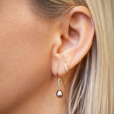 product_details::Poseidon Earrings and Huggie Gold Diamond Snack Hoop Earrings on model.