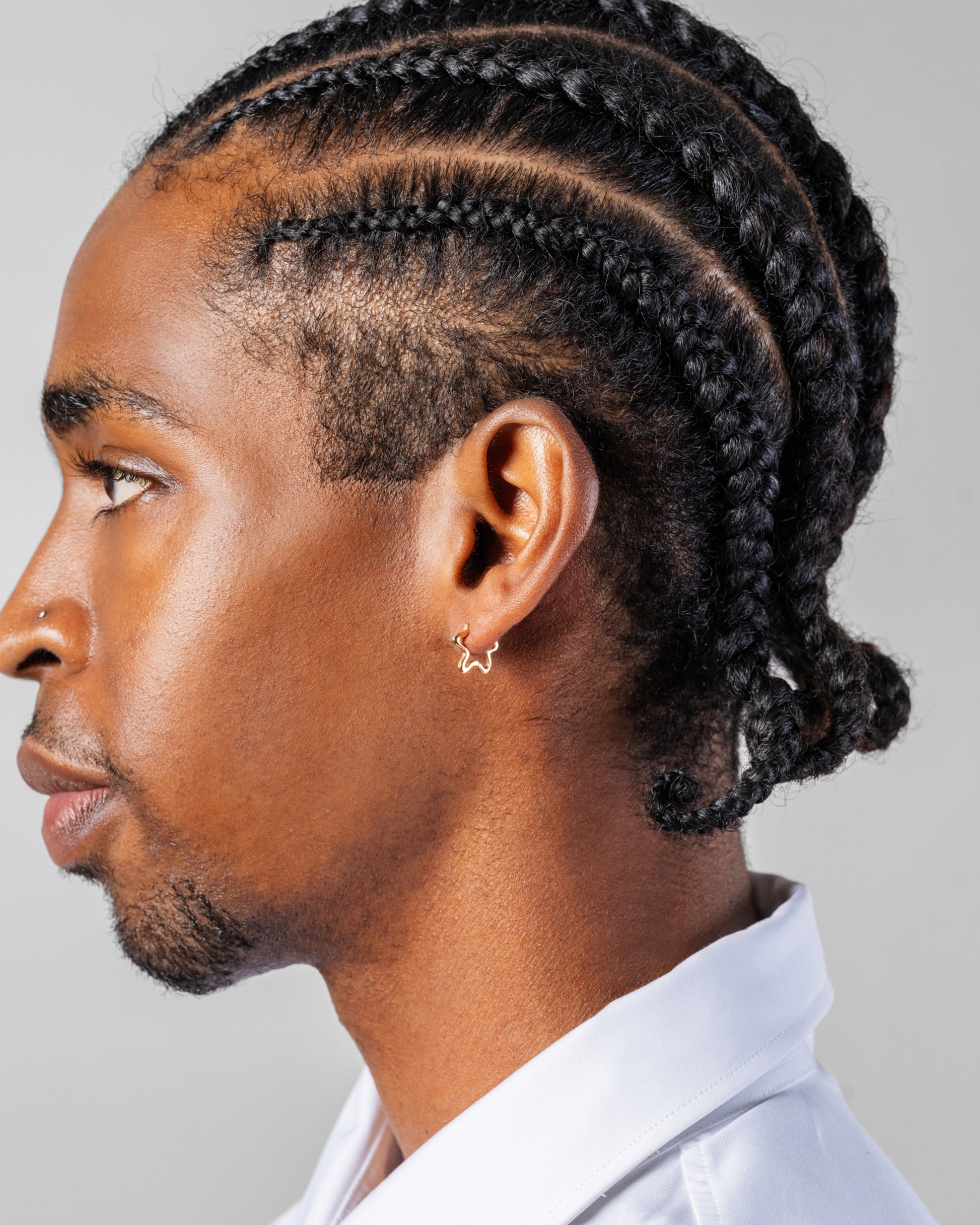 Gold Snow Flower Huggie Hoop Earrings on male model.