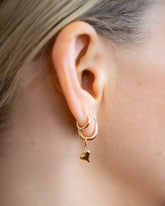 Styling Huggie Hoop Earrings and Heart Charm styled with Huggie Gold Snack Hoop Earrings on model.
