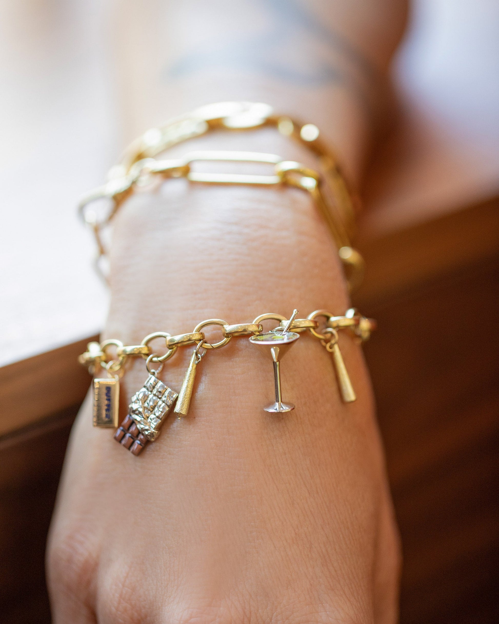 Stick of Salted Butter Charm, Joint Charms, Chocolate Bar Charm and Dirty Martini Charm paired with Gold Endless Clasp Bracelet on model.