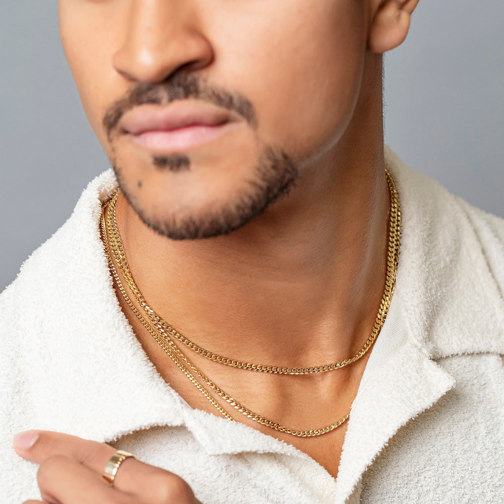 product_details::2.4mm Curb Chain Necklace, 3.4mm Curb Chain Necklace and Gold 5mm Etched Lines Band on male model.