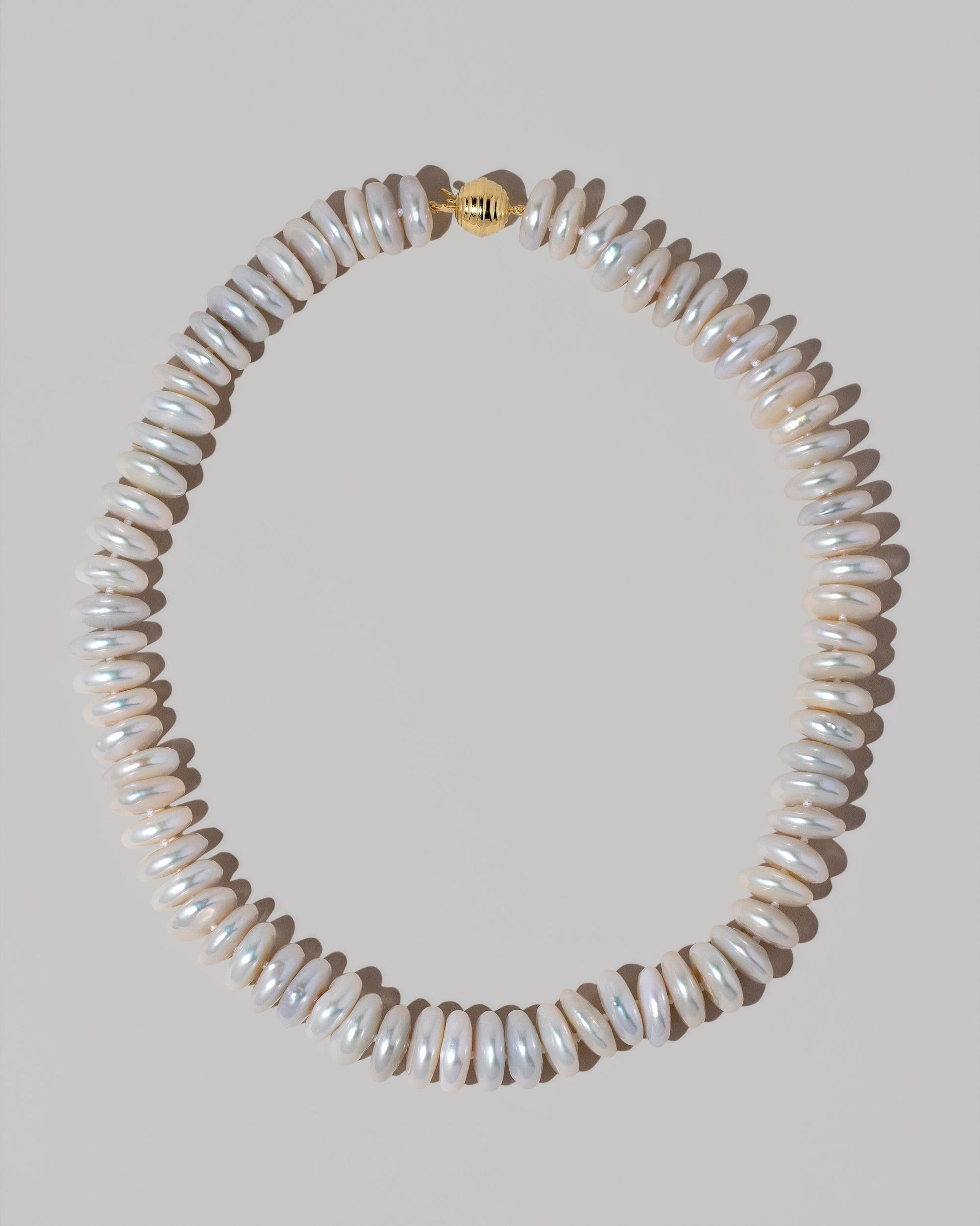 Snow Cap Pearl Necklace on light color background.