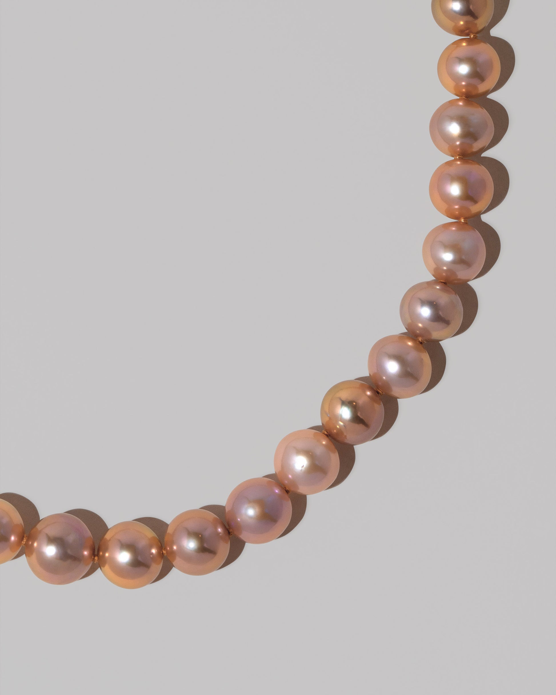 Closeup details of the Petite Sugar Pearl Necklace on light color background.