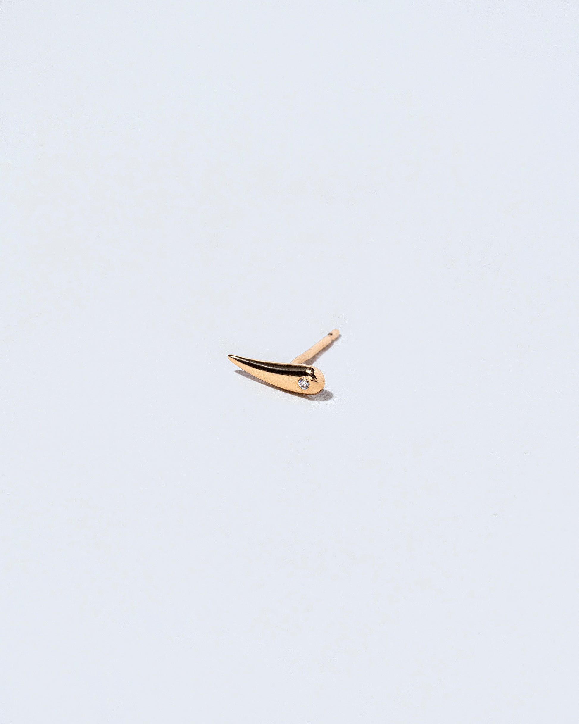 Gold White Diamond Left Facing One & Others Stud Earring Single on light color background.