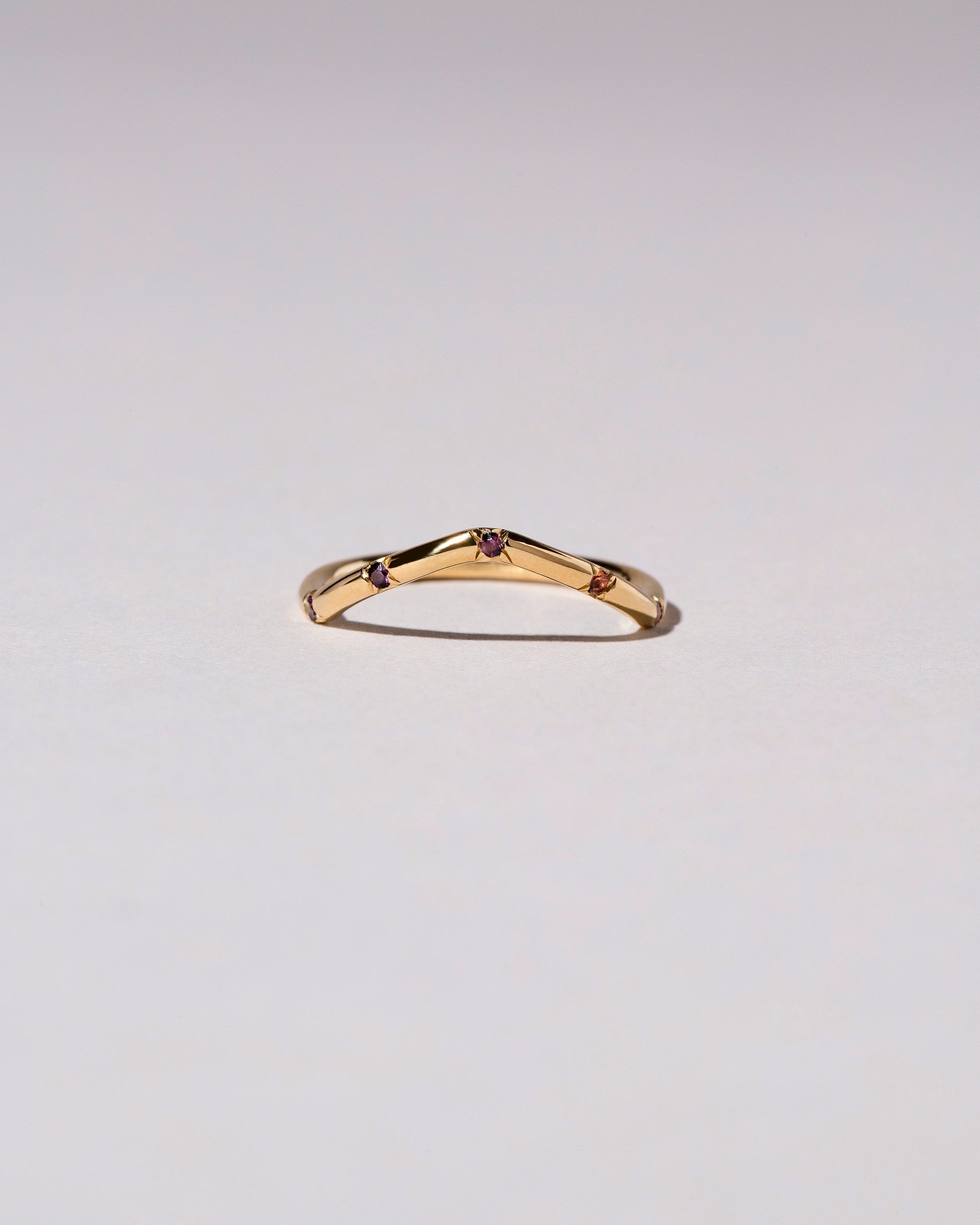 Gold Five Stone Garnet High Peak Band on light color background.