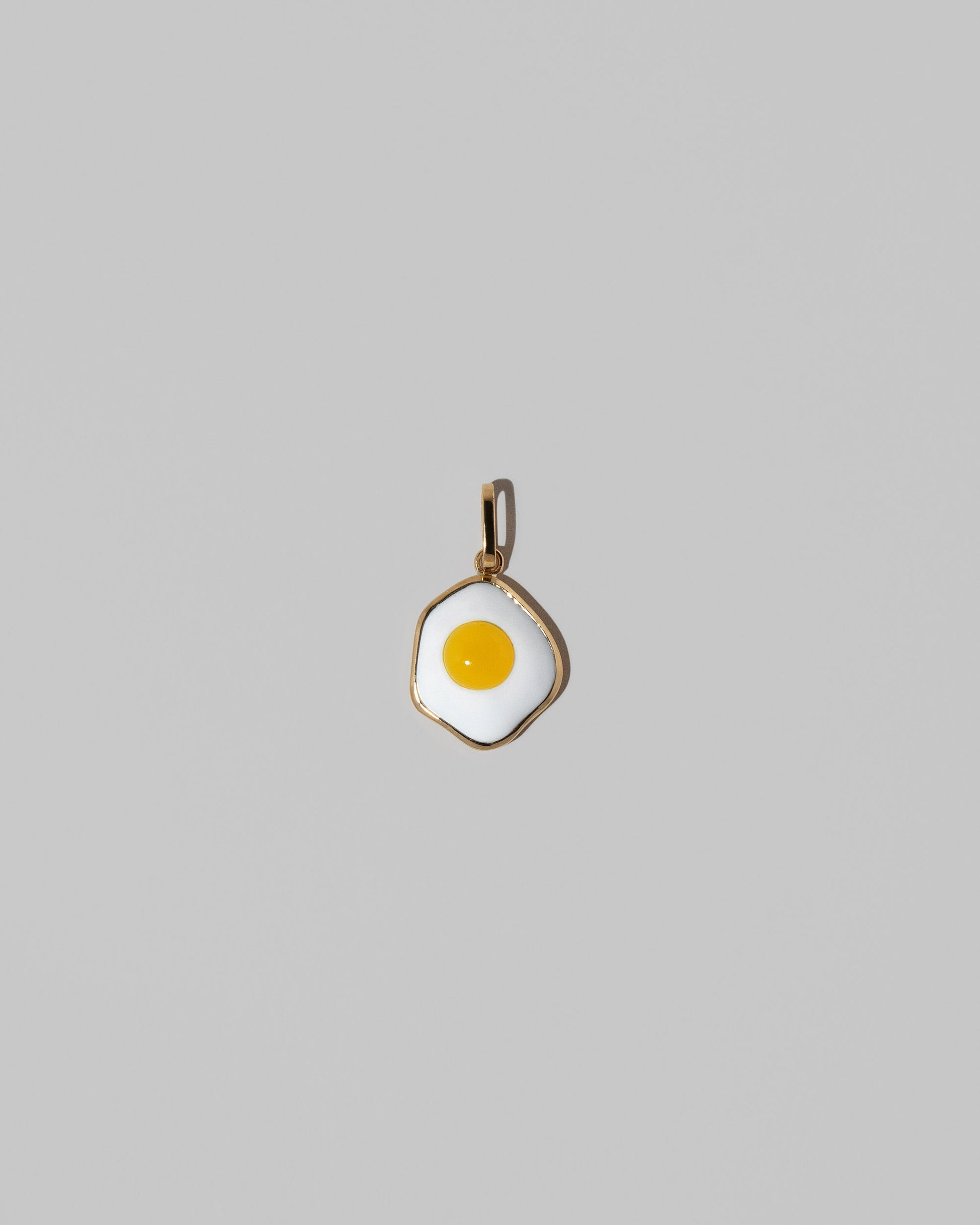 Fried Egg Pendant on light color background.