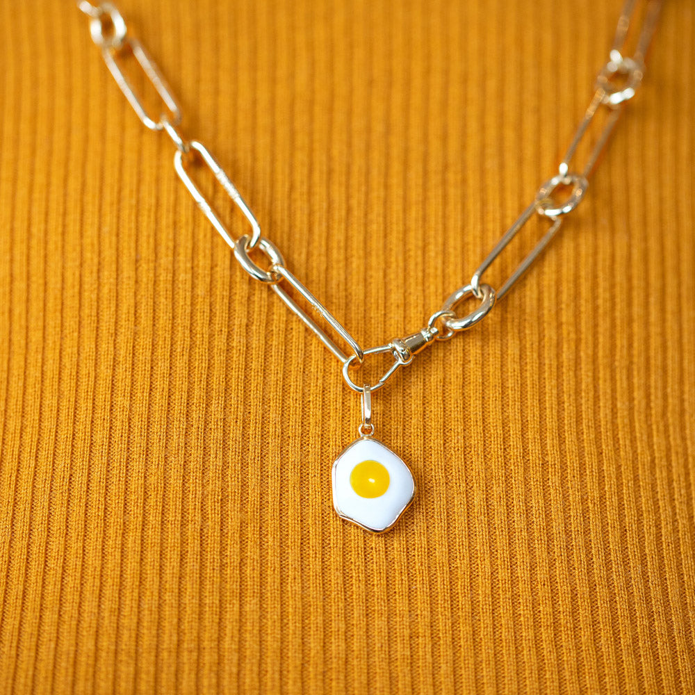 product_details::Closeup details of the Fried Egg Pendant and Solid Gold Link Necklace on model.