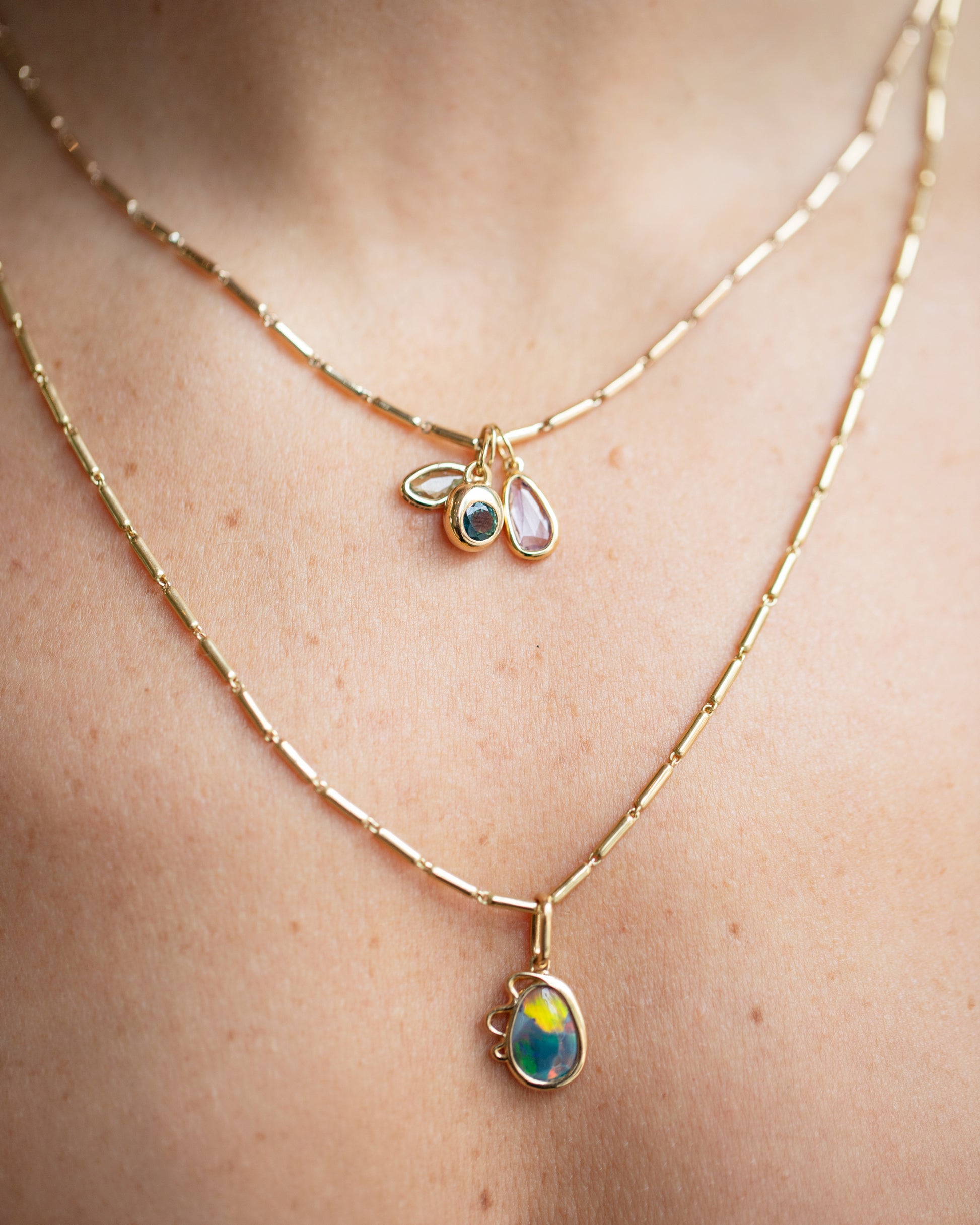 Harmony Pendant, Sapphire Birthstone Level Charm and Purple and Yellow Sapphire Gusher Charm with Gold Butter Chain Necklaces on model.