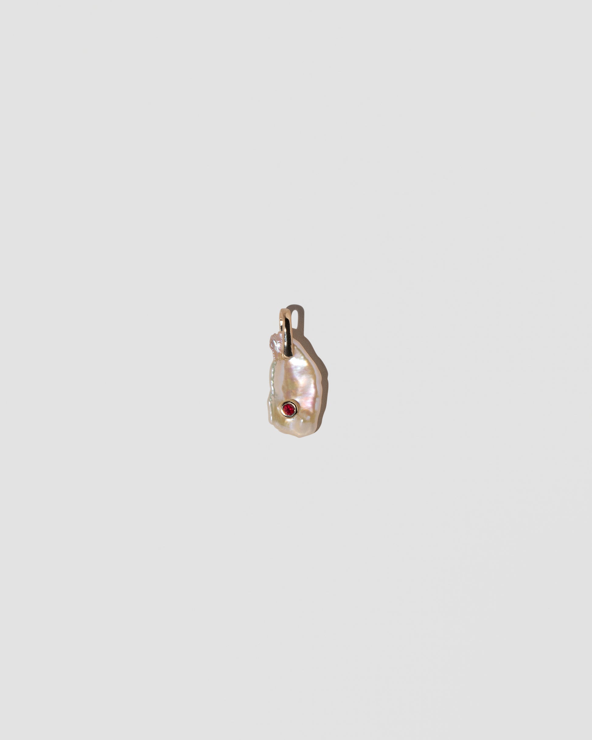 January Birthstone Pearl Pendant With Garnet on light color background.