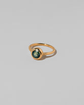 View from the side of the Teal Sapphire Wellspring Ring on light color background.