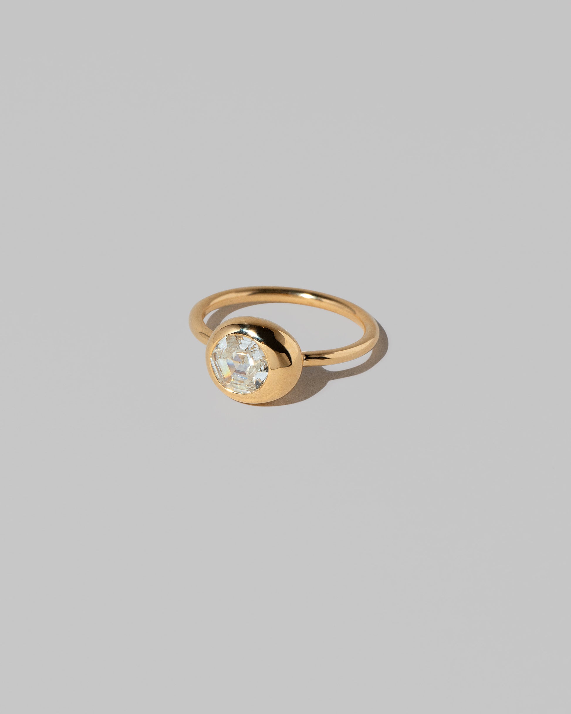 View from the side of the Step Cut Diamond Grand Level Ring on light color background.