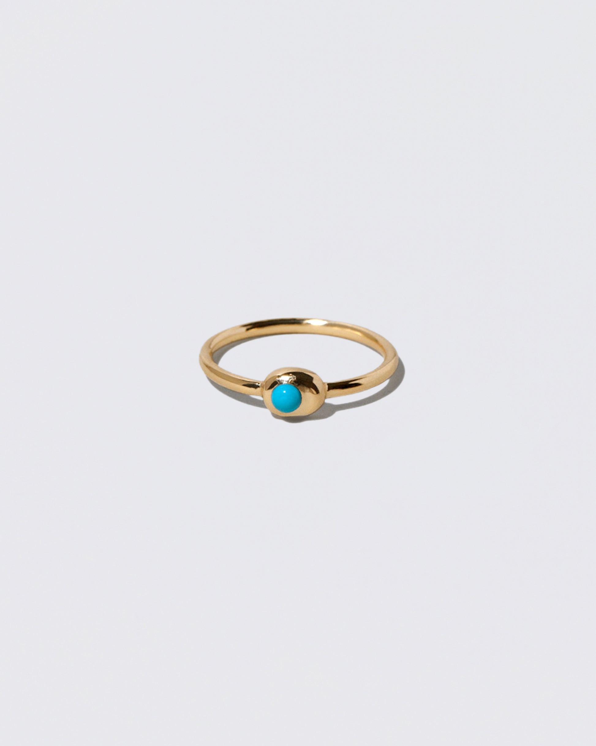 Turquoise Cabochon Birthstone Level Ring on light color background.