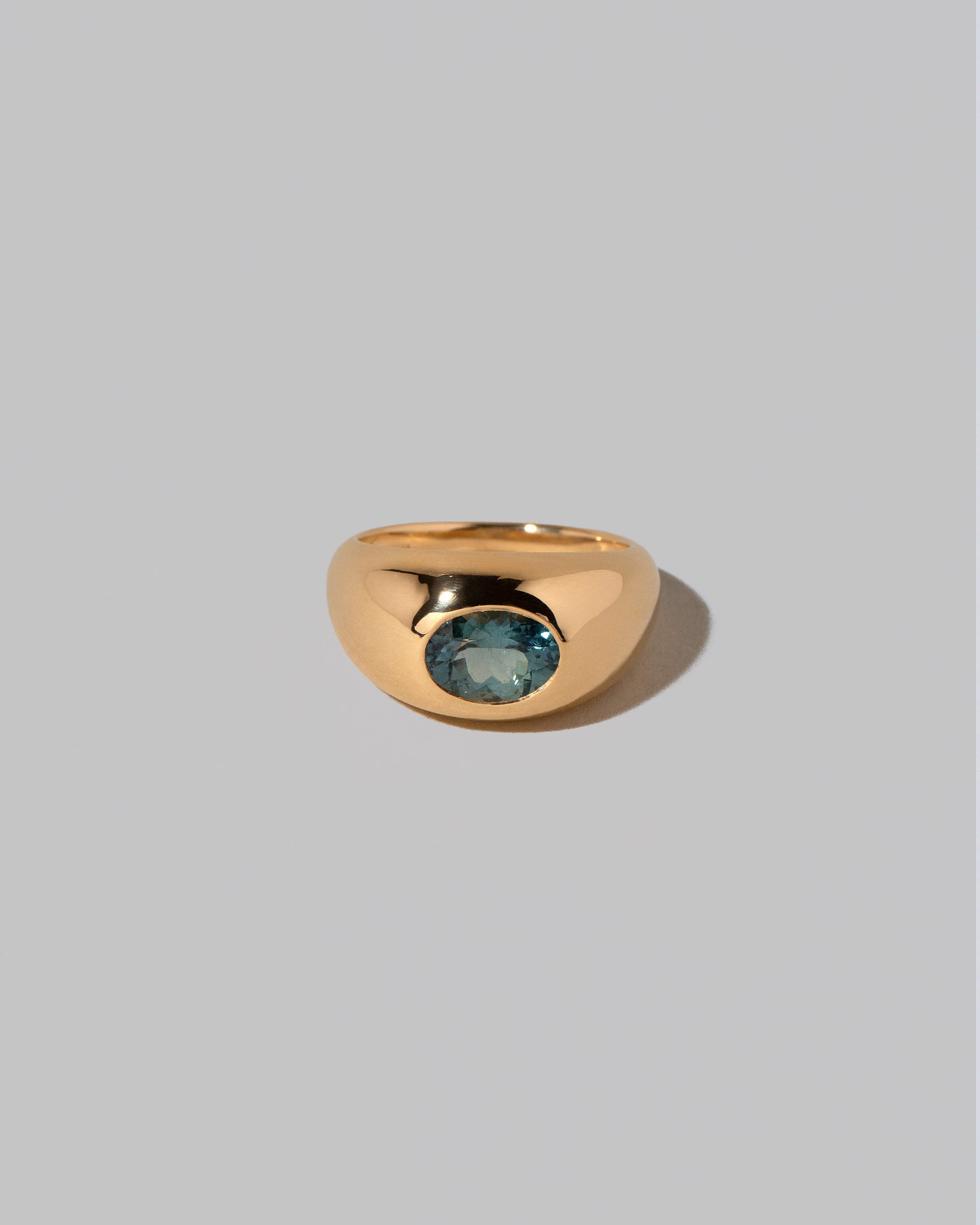 Teal Sapphire Jupiter Ring on light color background.