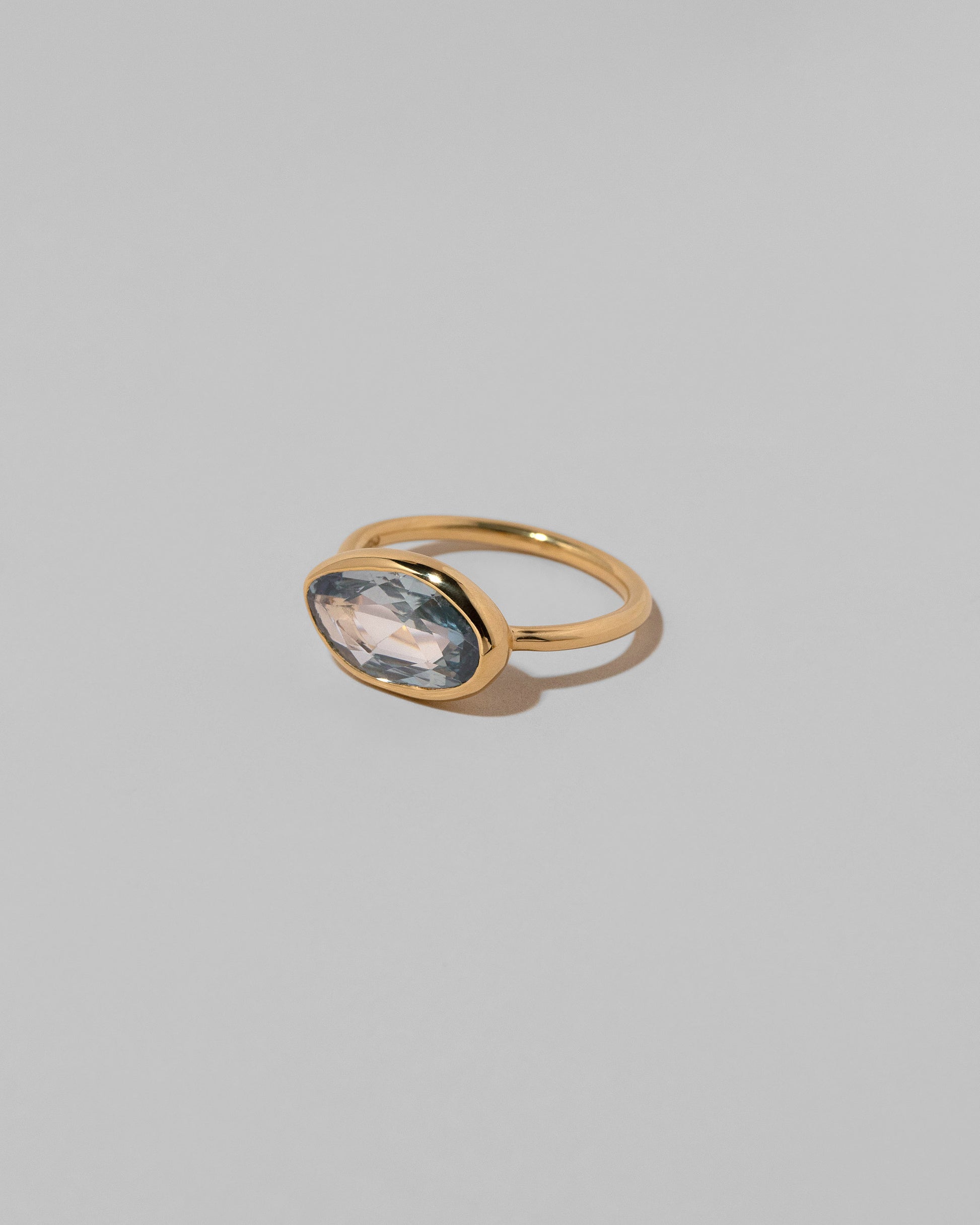 View from the side of the Gusher Blue Sapphire Ring 039 on light color background.