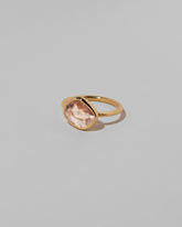 View from the side of the Gusher Pink Sapphire Ring 040 on light color background.