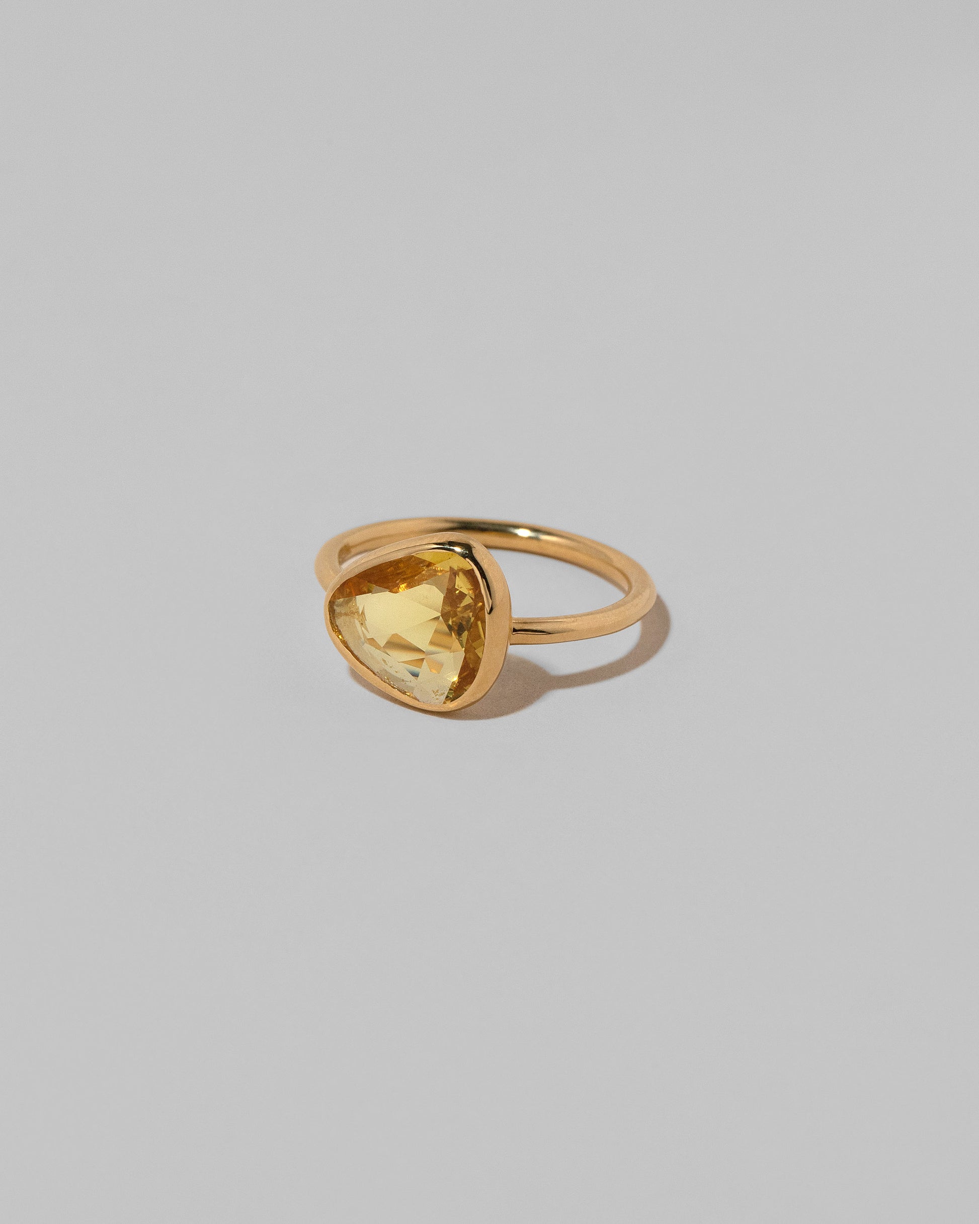 View from the side of the Gusher Yellow Sapphire Ring 035 on light color background.