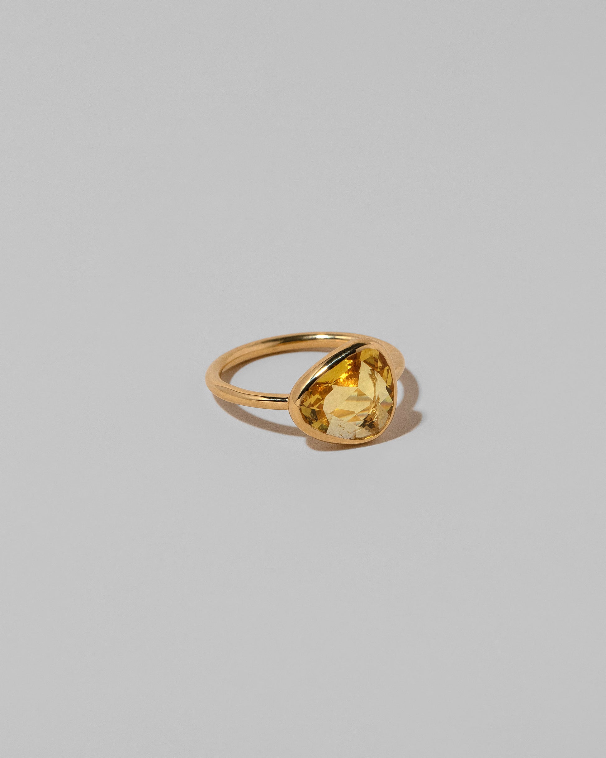 View from the side of the Gusher Yellow Sapphire Ring 035 on light color background.