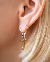 Sardine Fish Charm and Saltine Cracker Charm paired with Huggie Gold Solid Snack Hoop Earrings and styled with the Huggie Gold Diamond Snack Hoop Earrings on model.