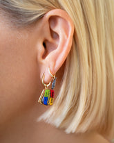 Sardine Can Charm paired with Gold Poppy Flower Bud Hoop Earrings and styled with the Sardine Fish Charm paired with the Huggie Gold Diamond Snack Hoop Earrings on model.