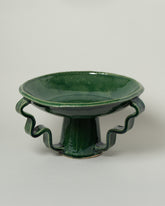 Closeup details of the Morgan Peck Glassy Green Stretch Bowl on light color background.