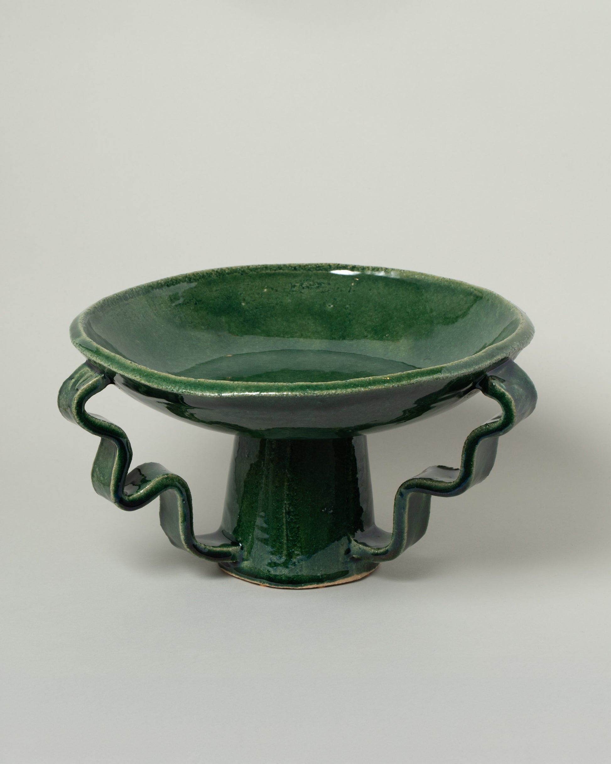 Closeup details of the Morgan Peck Glassy Green Stretch Bowl on light color background.