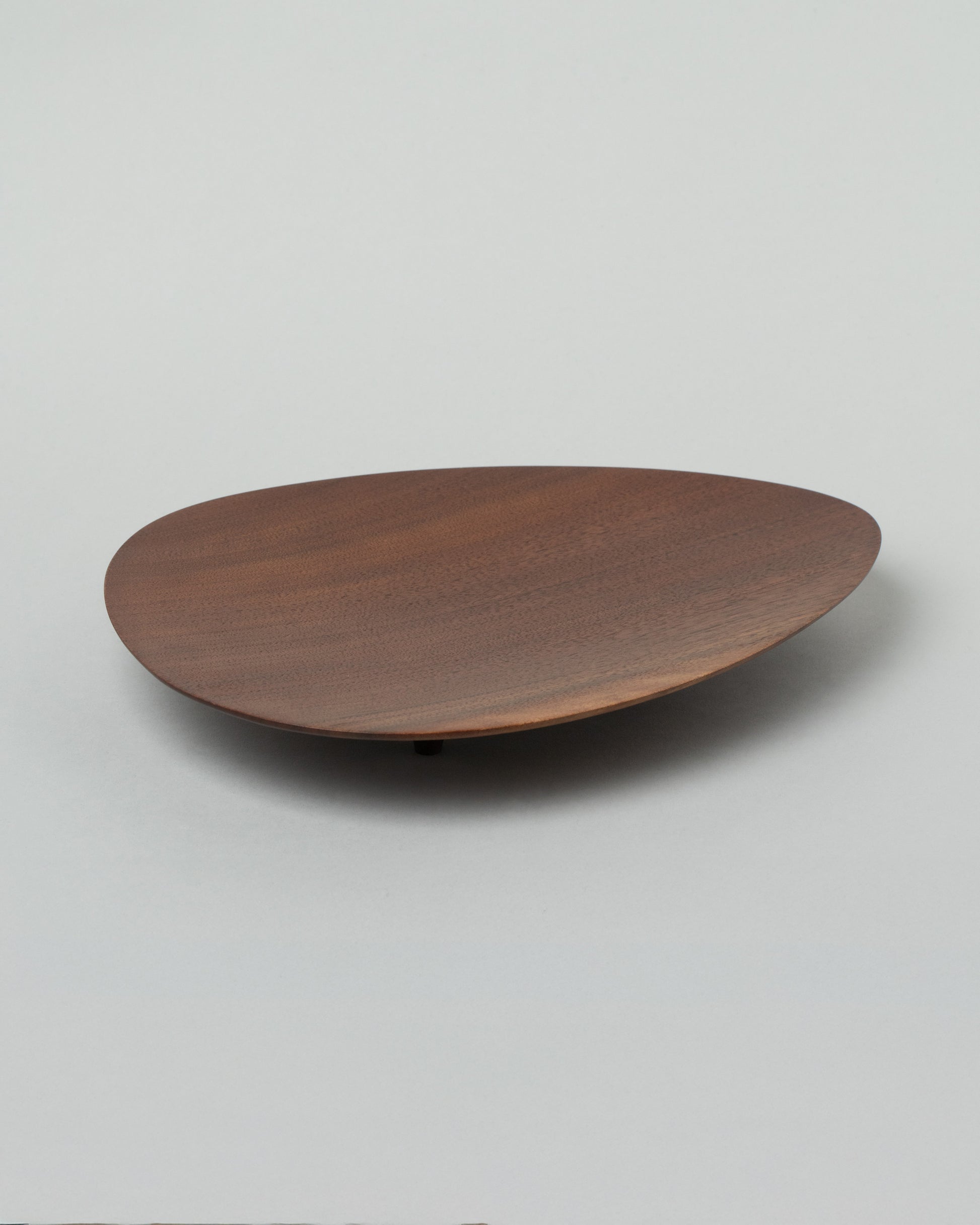 Namu Home Goods Black Walnut Asymmetrical Footed Plate on light color background.