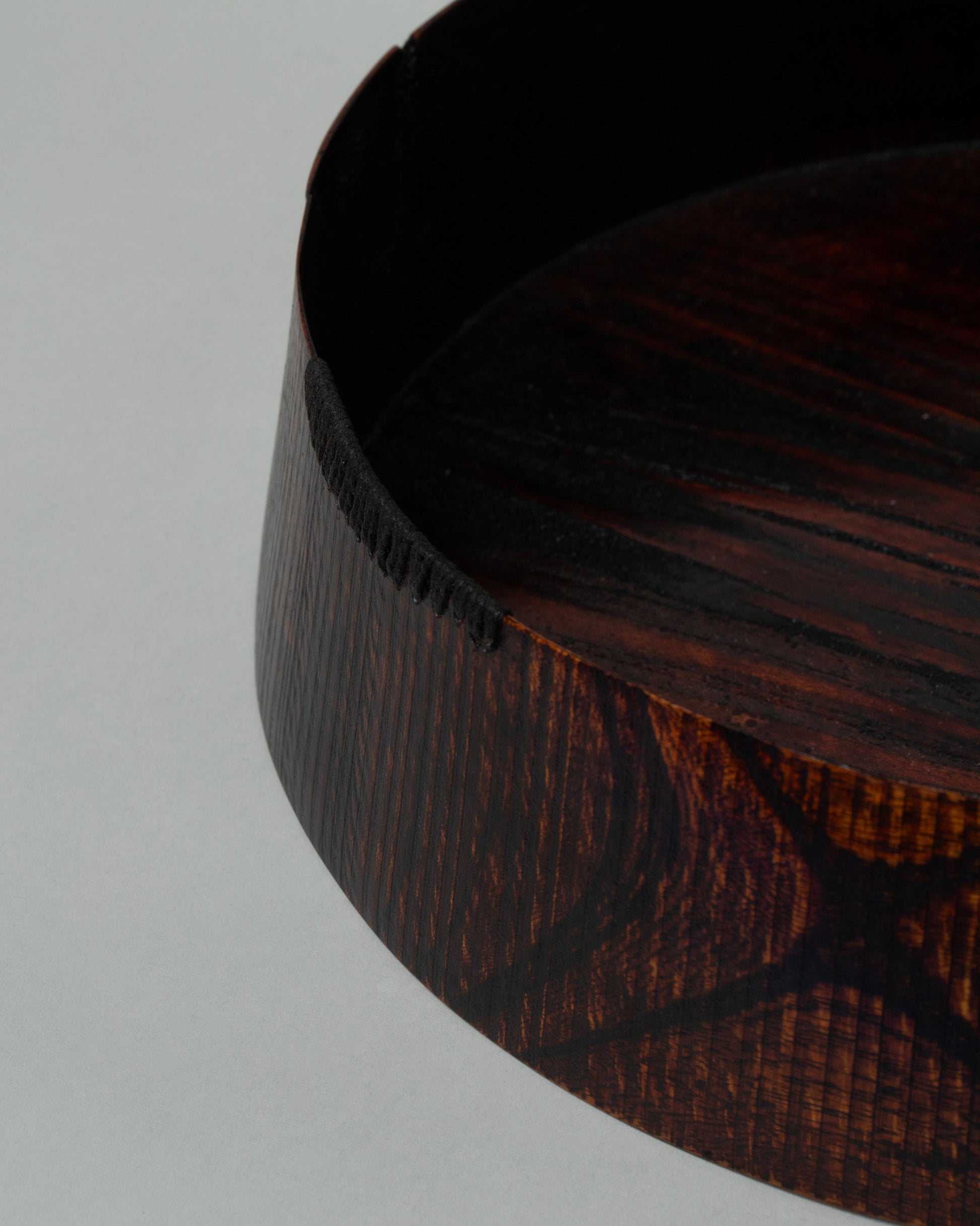 Closeup details of the Namu Home Goods Zelkova Wood Medium Red Lacquered Bowl on light color background.