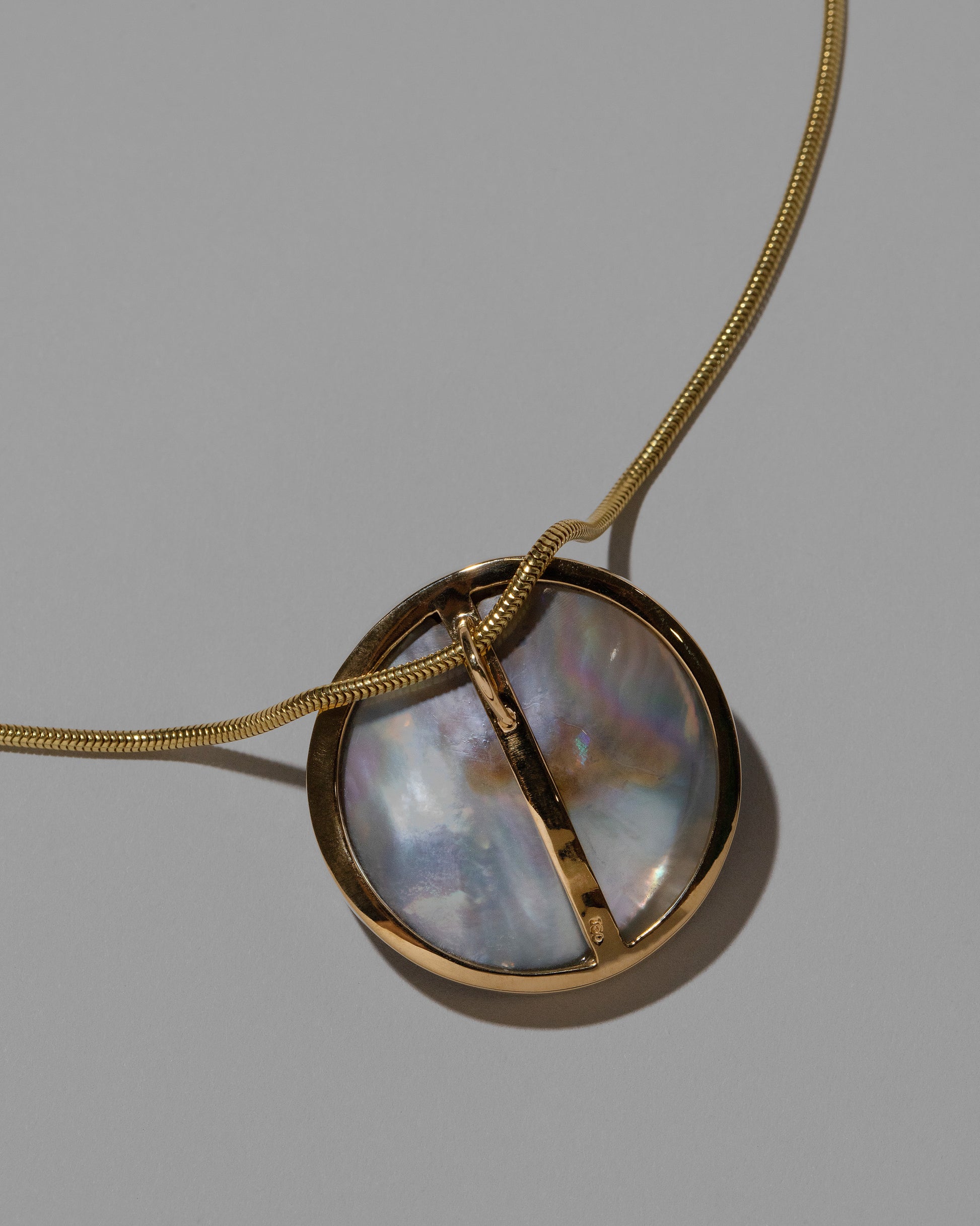 View from the back of the Seeing the Unseen Necklace on light color background.