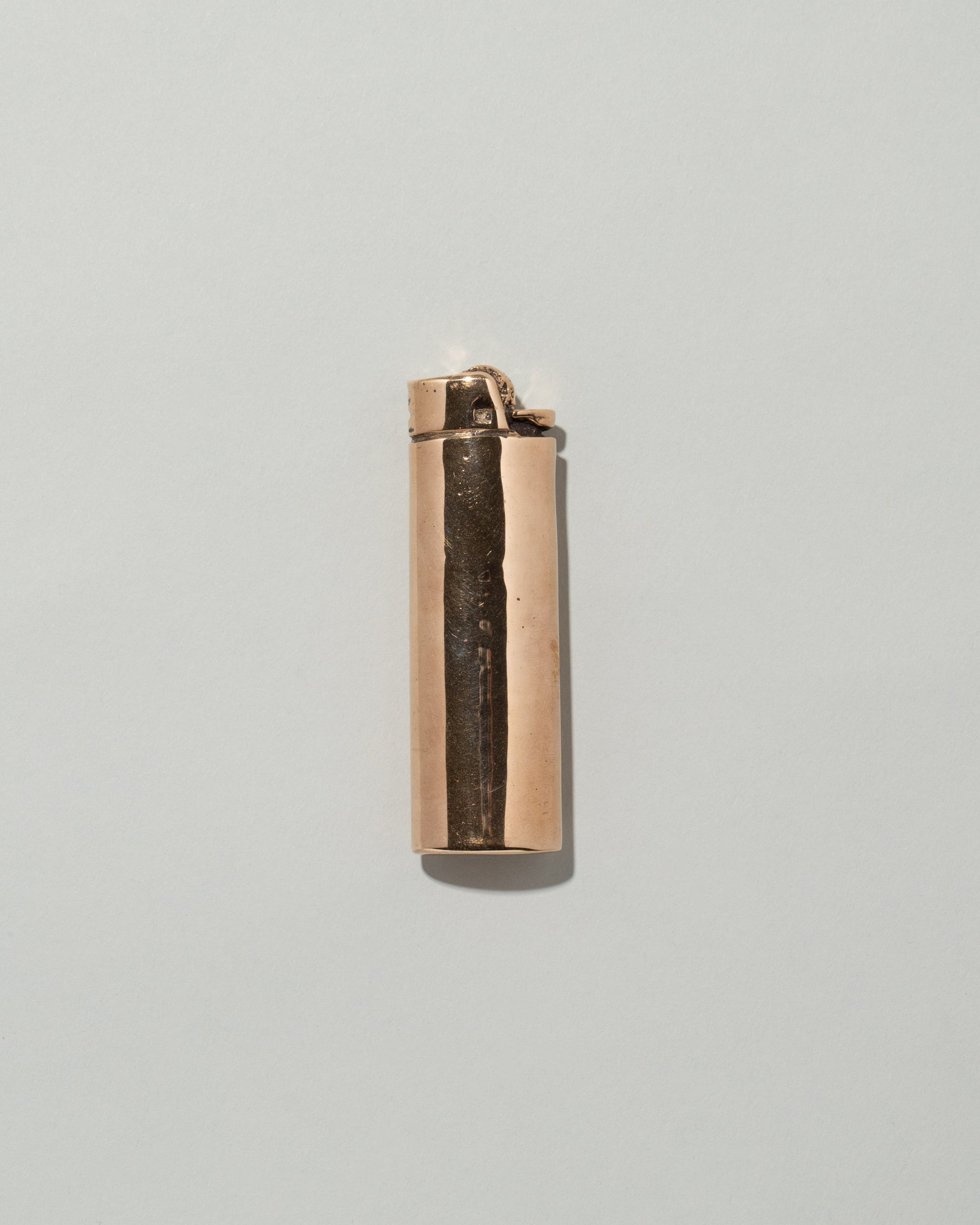 Pearce Objects Cast Bronze Lighter on light color background.
