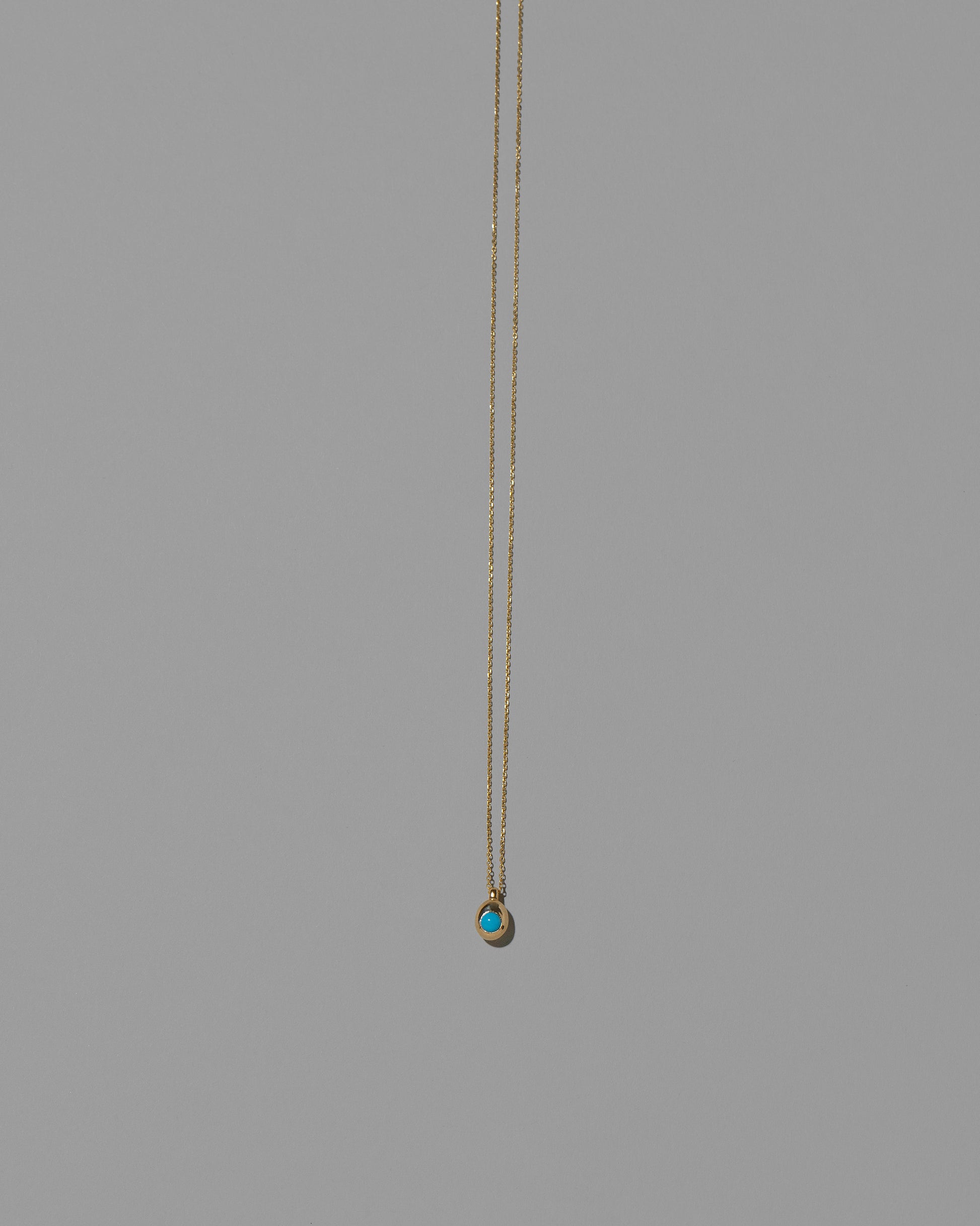 Turquoise Cabochon Birthstone Level Necklace on light color background.