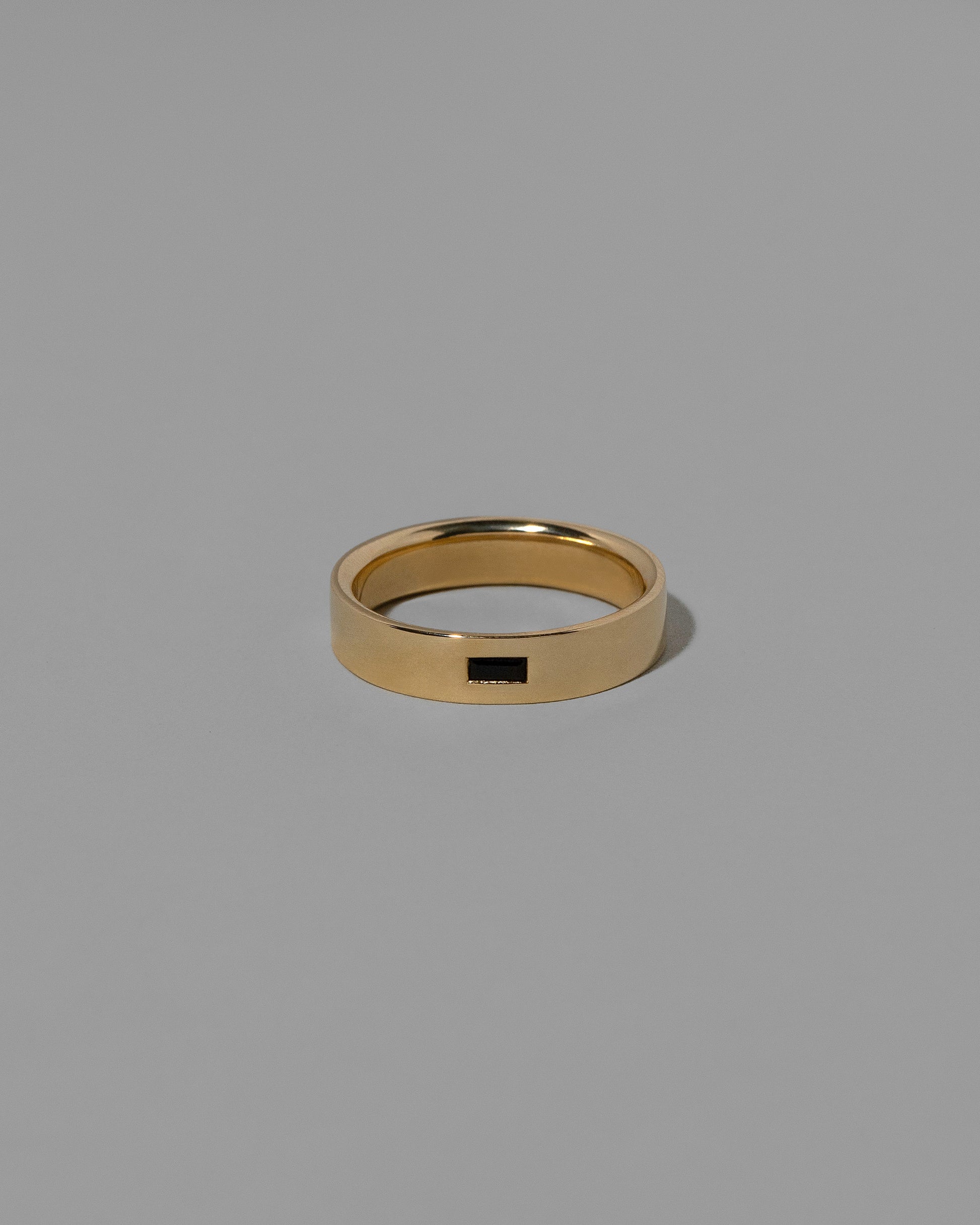 Gold Black Spinel East West 5mm Baguette-Set Piet Band on light color background.