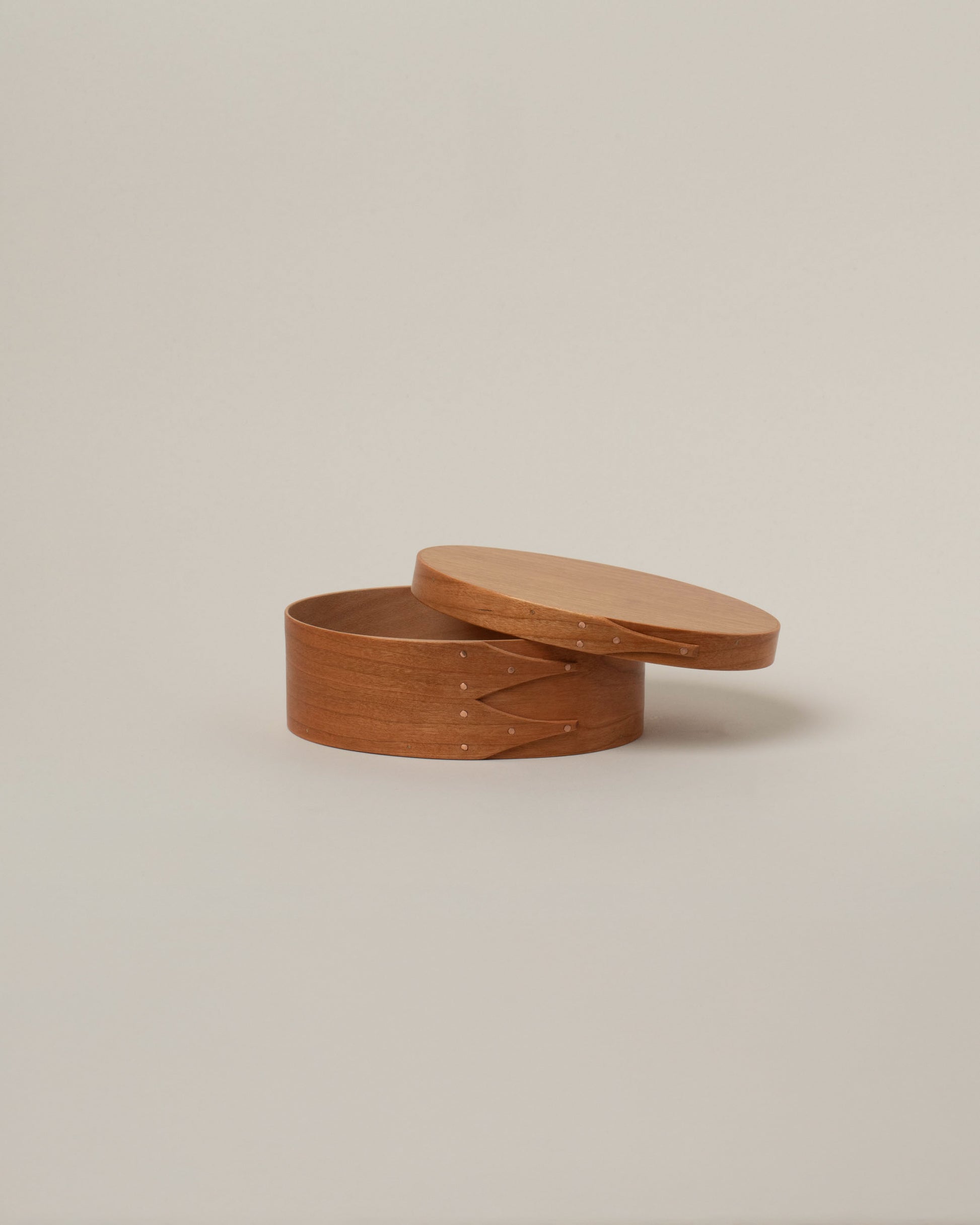 Detail view of the Rikke Falkow Extra Small Cherry Wood Oval Box on light color background.