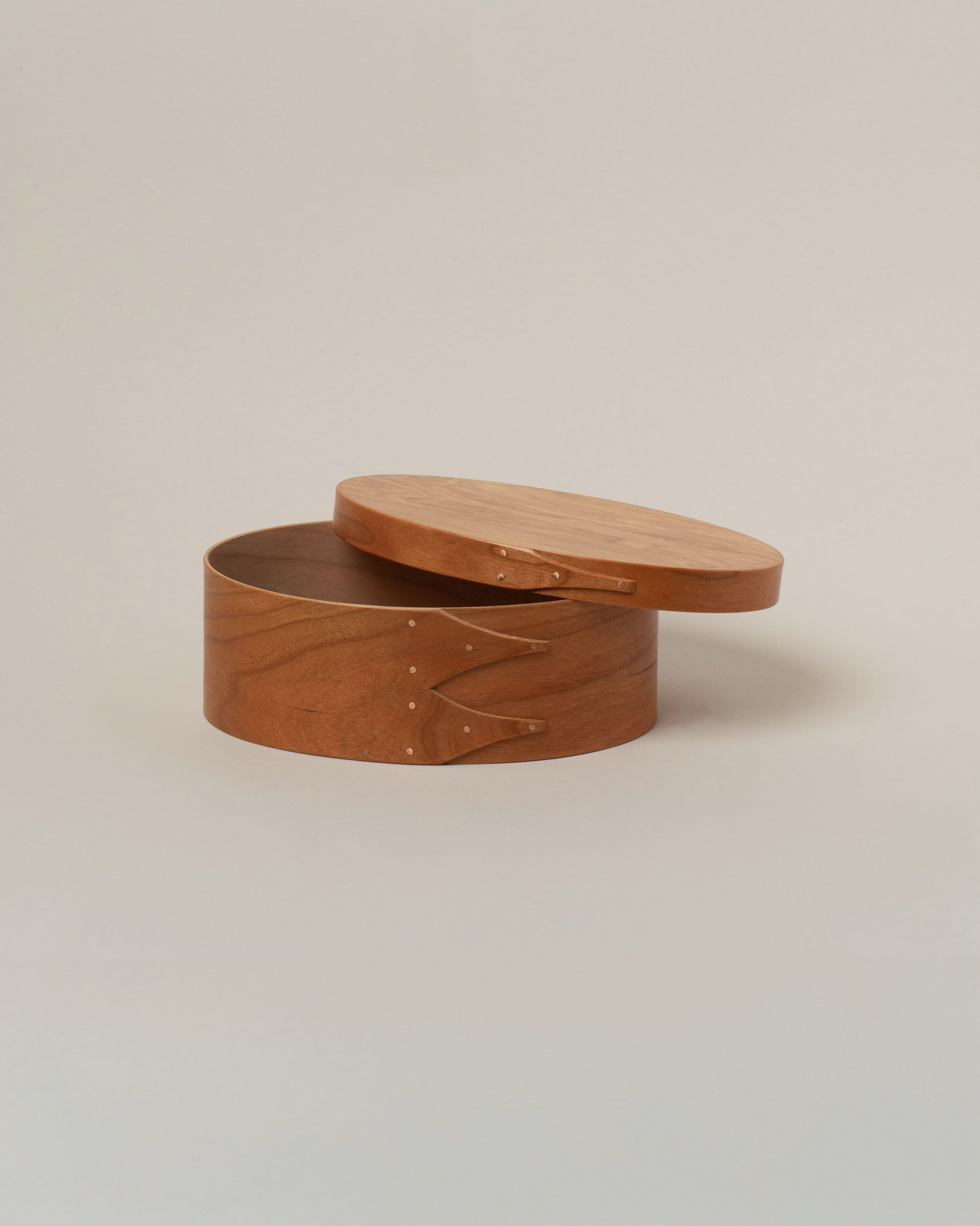 Detail view of the Rikke Falkow Small Cherry Wood Oval Box on light color background.