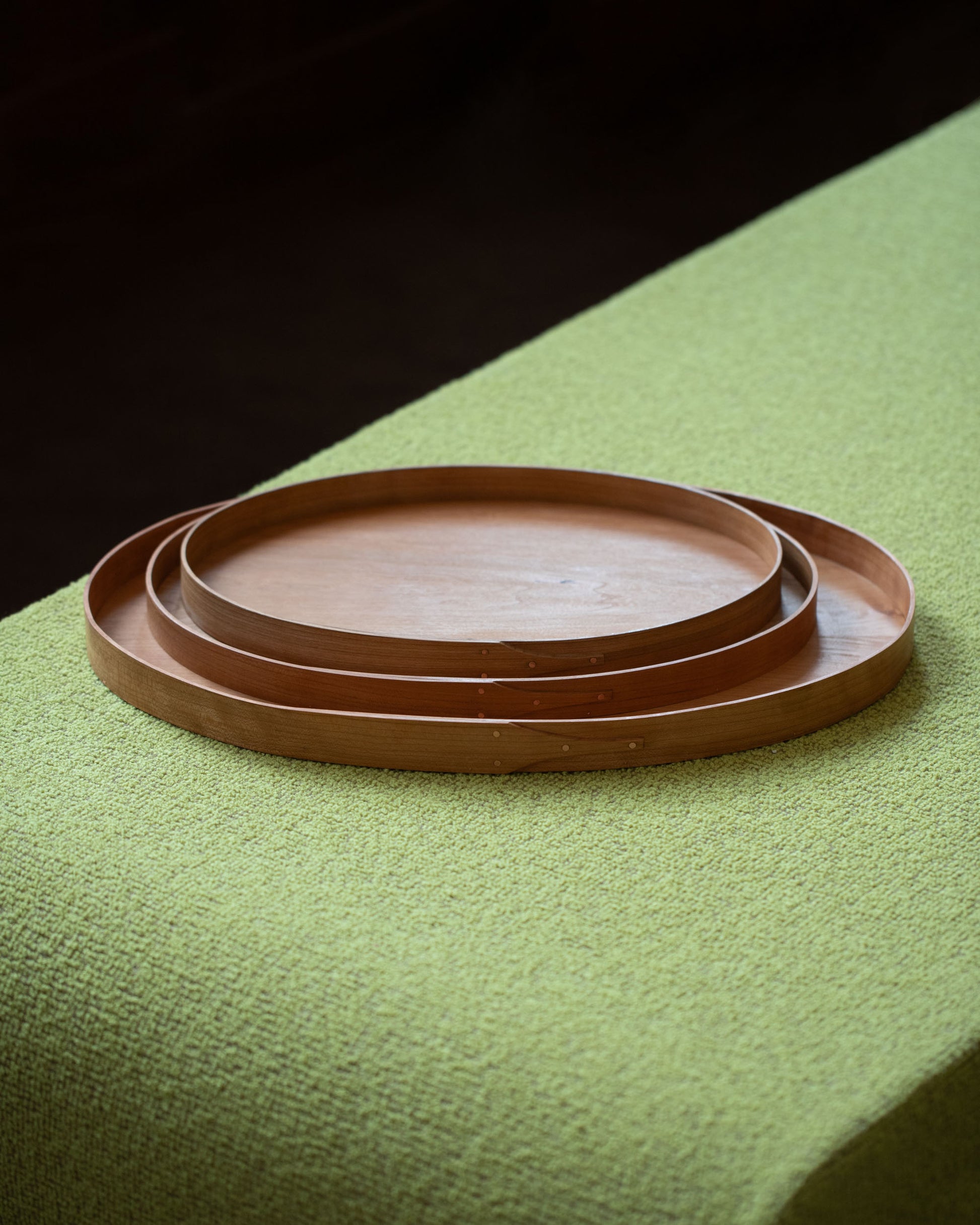 Rikke Falkow Large Cherry Wood Serving Tray, Rikke Falkow Medium Cherry Wood Serving Tray and Rikke Falkow Small Cherry Wood Serving Tray on light color background.